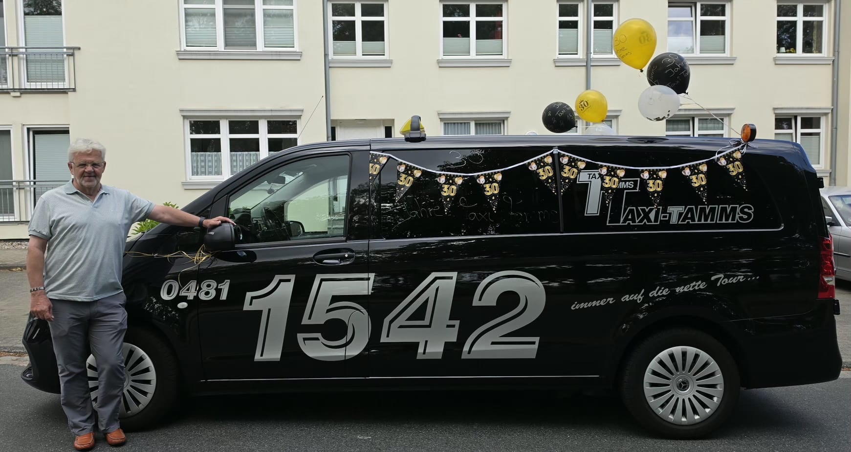 Ingo Tamms vor dem Taxi-Tamms Van mit 30-Jahre-Ballons in Heide